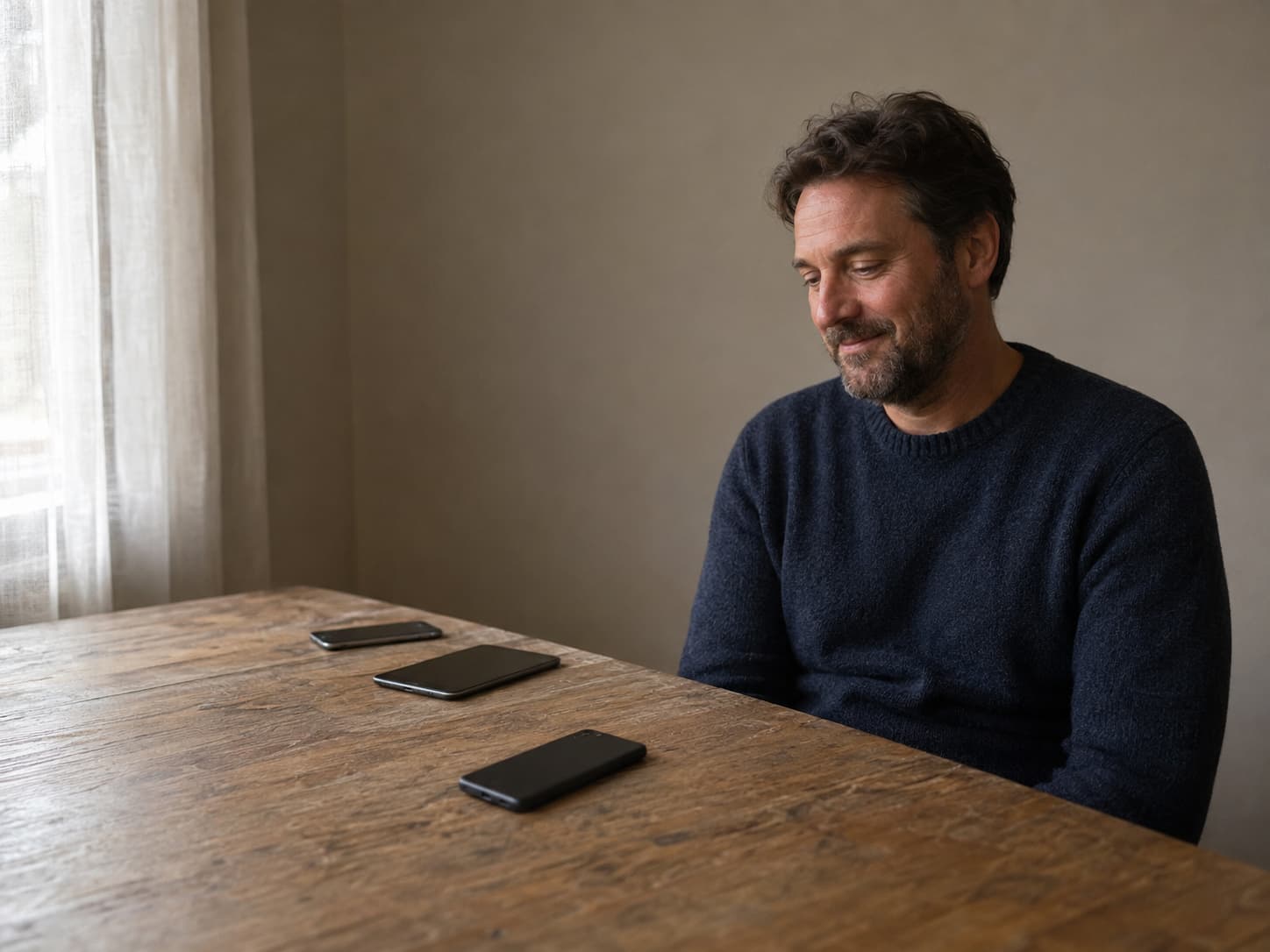 A customer considering three old devices arranged on a wooden table at home